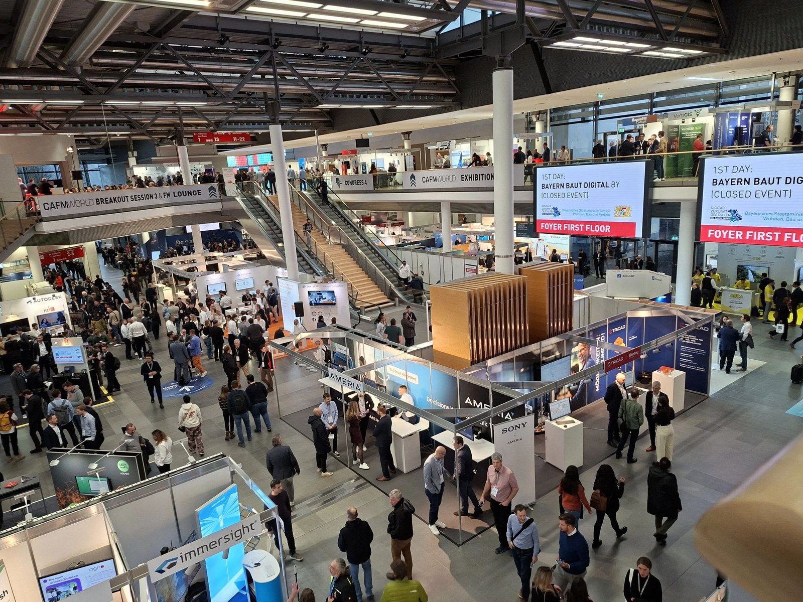 BIM World Munich 2025 exhibition floor overview from upper-level vantage point — large convention hall with hundreds of attendees.