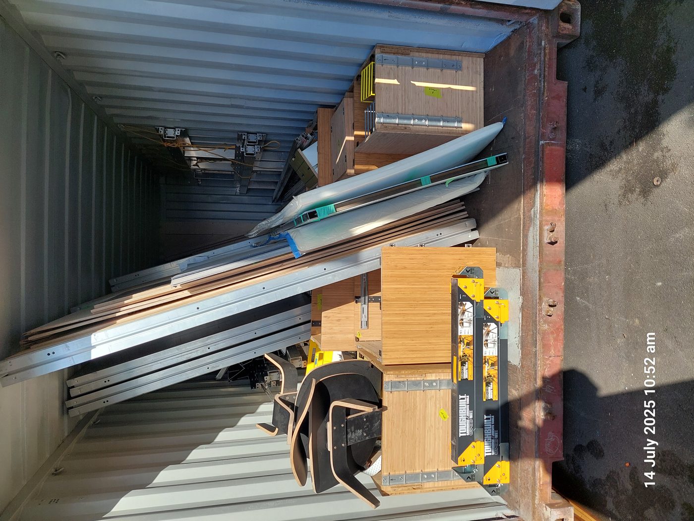 Interior of shipping container showing packed aluminum extrusions, Payload cabinet boxes, and finishing components for two complete Anyplace units